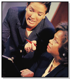 A standing woman presenting a proposal to a seated woman.